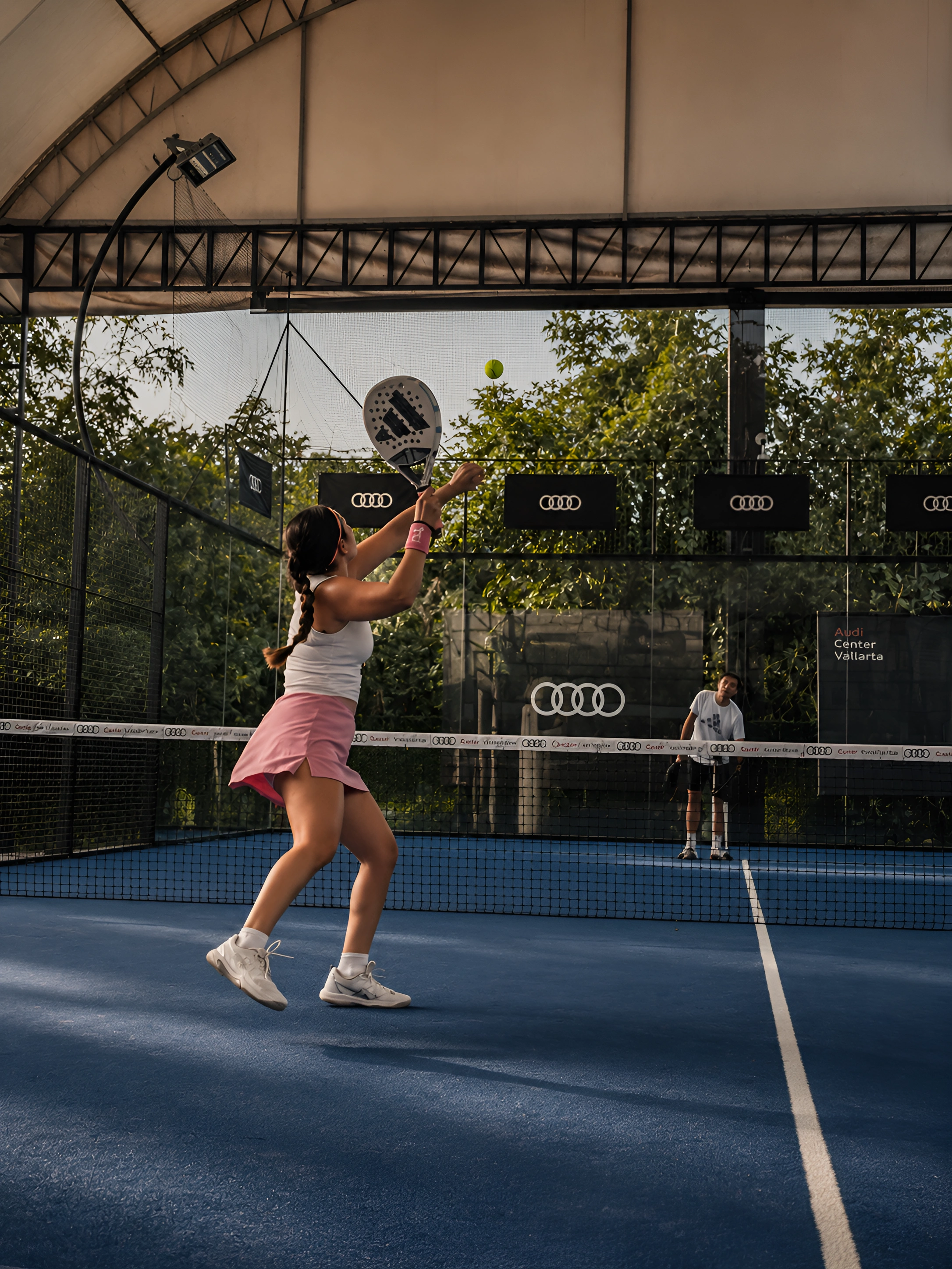 Jugadora practicando un golpe durante una clase de pádel en Padel 233 Puerto Vallarta